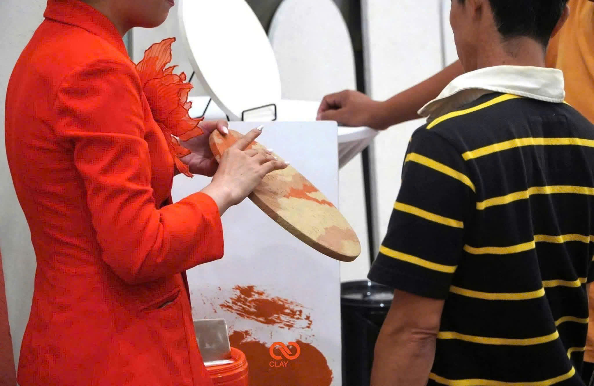 A PUKACO team member presenting a textured finish sample to visitors in the showroom.