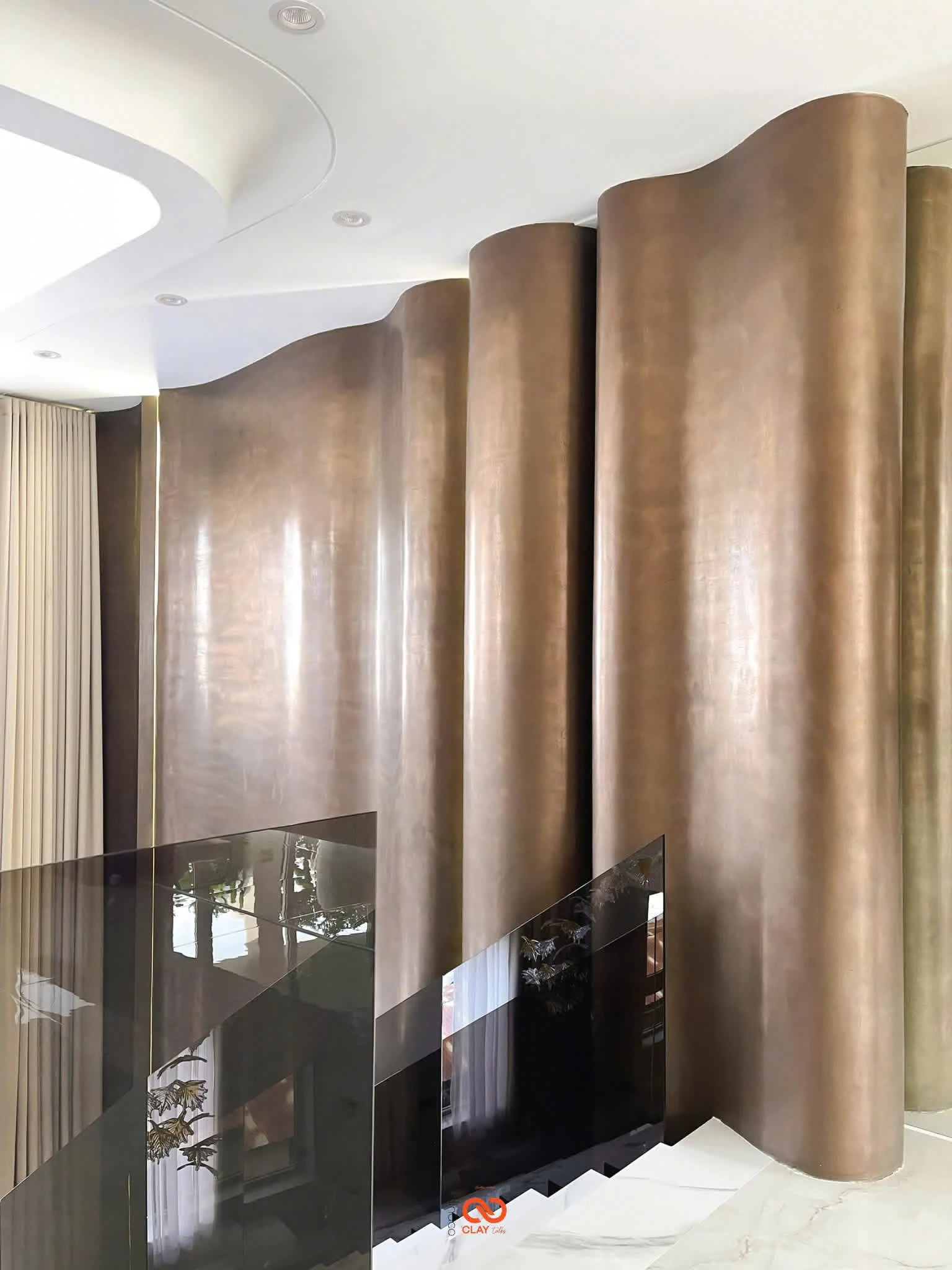 A tall bronze-finish wall beside an interior staircase.