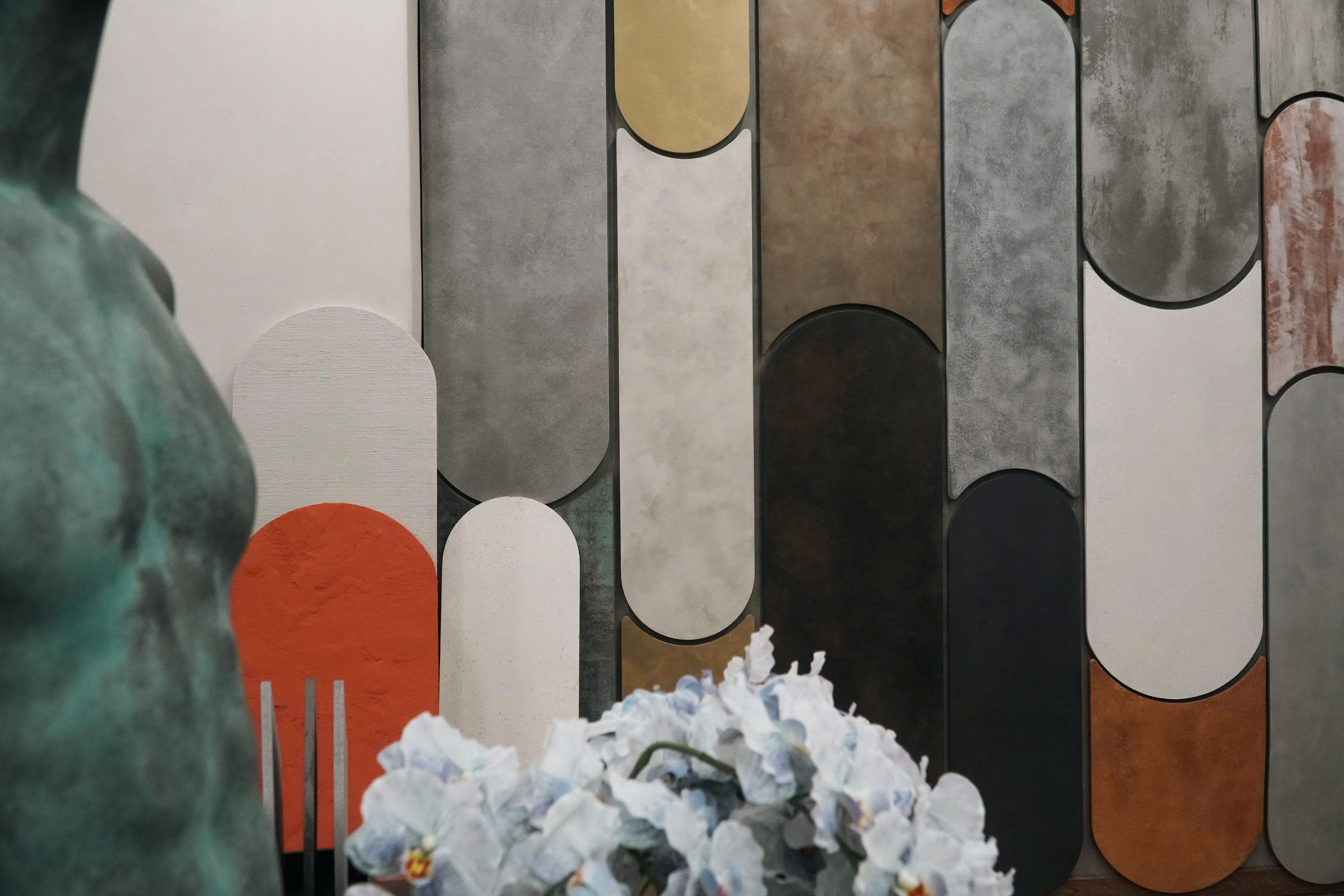 Original PUKACO showroom photograph with a wall of tall curved finish samples in ivory, ochre, gray, orange and charcoal.
